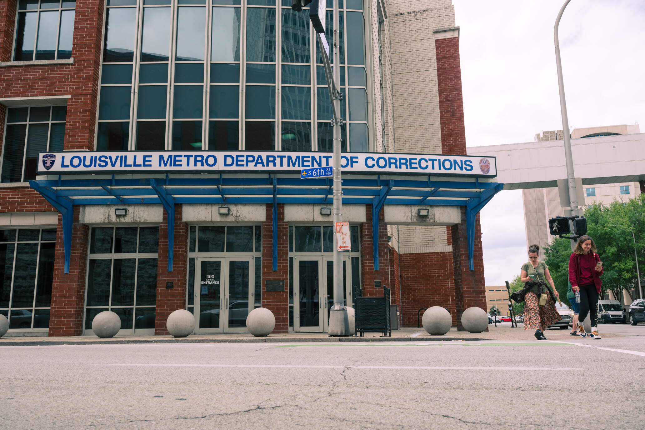 Pedestrians cross in front of the Louisville Metro Department of Corrections on August 22, 2025 in Louisville, Kentucky. (Jon Cherry for Here &amp; Now)