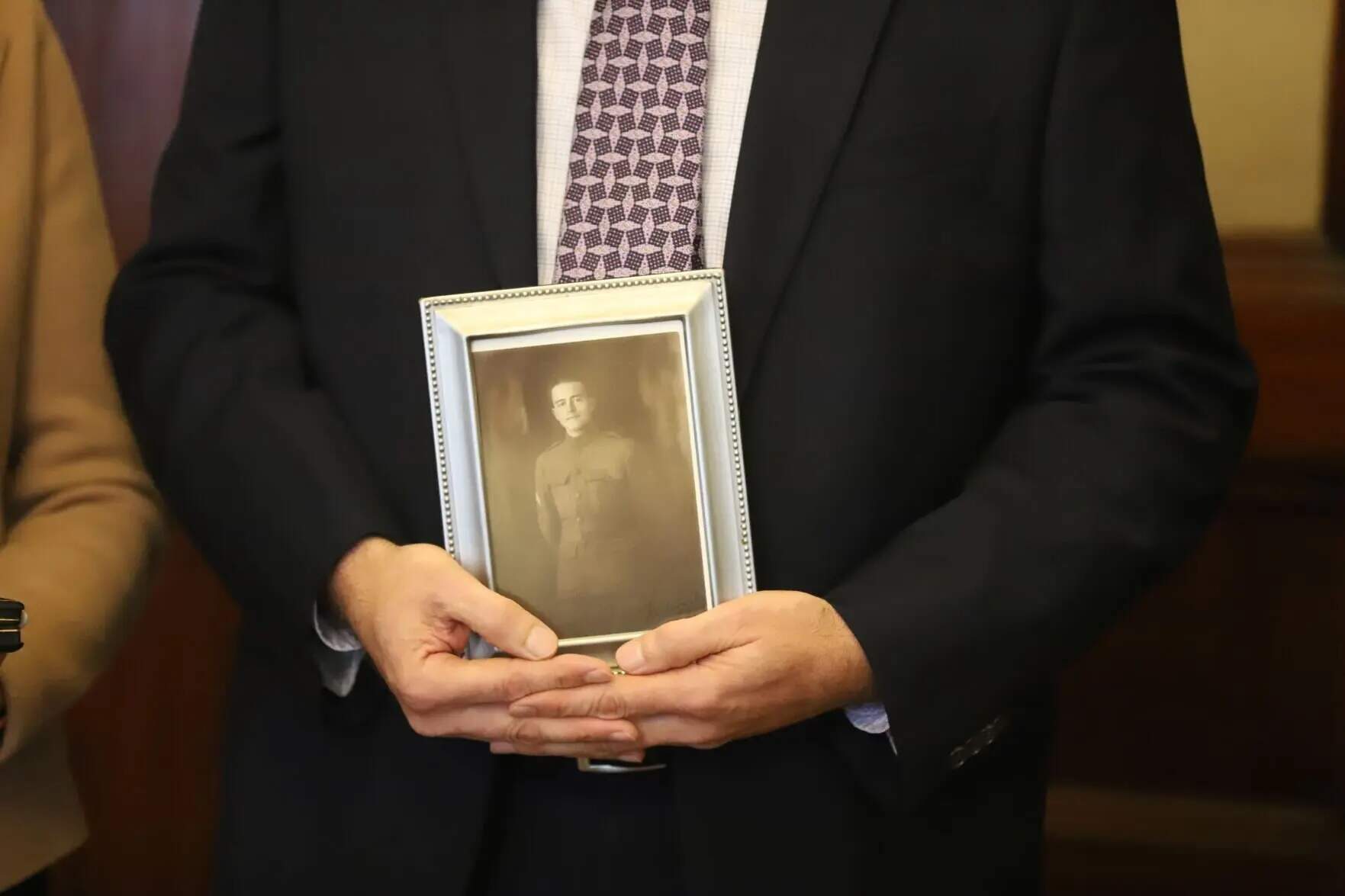 Thomas Brigham, the grandson of Purple Heart recipient Sgt. Thomas Flynn, holds a photograph of his grandfather. (Colin A. Young/SHNS)