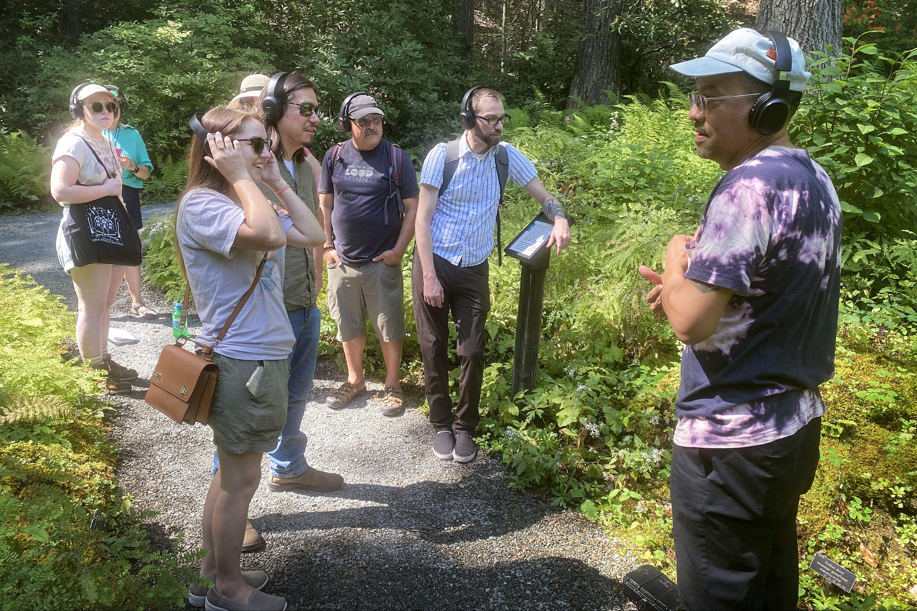 Workshop participants wear radio headphones tuned into micro broadcasts of sounds captured by Skooby Laposky's sensitive microphones. (Andrea Shea/WBUR)