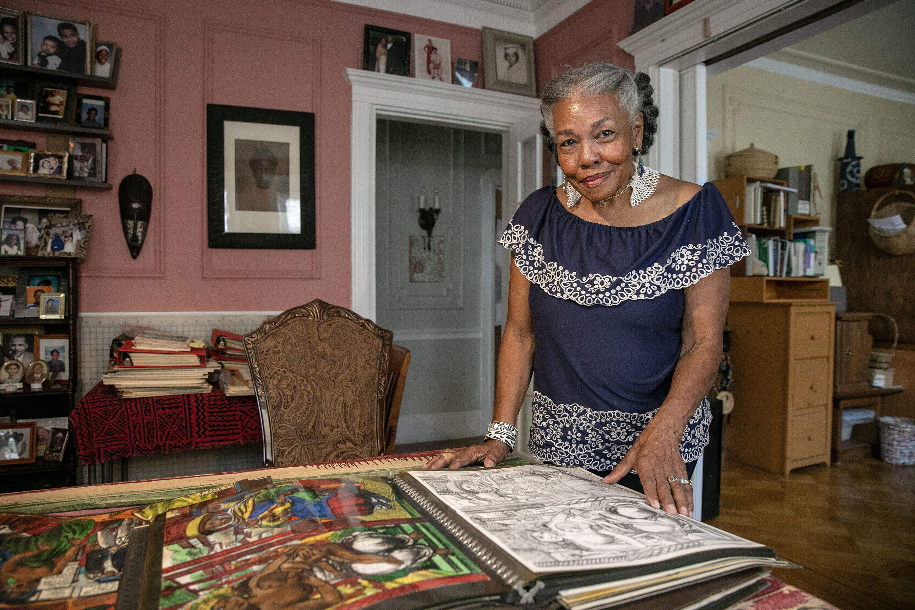 Artist Susan Thompson with a folder of Allan Rohan Crite's work. (Robin Lubbock/WBUR)