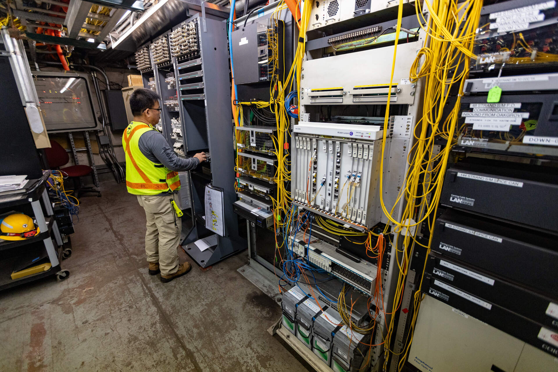 A signal worker monitors The Modernized Equipment In ONE OF THE UPGRRADED sign. The Room Was Onher Rilld WITH AISES OF Electromechanromechaechecanical Relays, WHICH HAVE BEEN LED RELAYS, WHICH HAVE BEEN LED RELAYS, WHICH HAVE BEEN LED REMOVED AND REPLACEED WITH MICROPSSOCRACESOCRACEED WITH. (Esse costa / wbur)