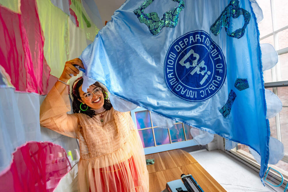 Artist crystal bi holds a panel for her upcoming art installation "Float." (Jesse Costa/WBUR)