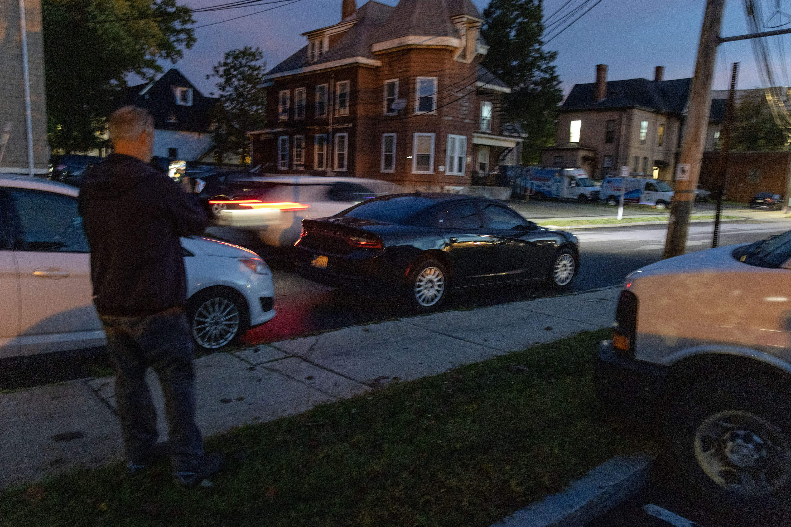 A volunteer with LUCE observes a vehicle on Pearl Street in Framingham. (Robin Lubbock/WBUR)