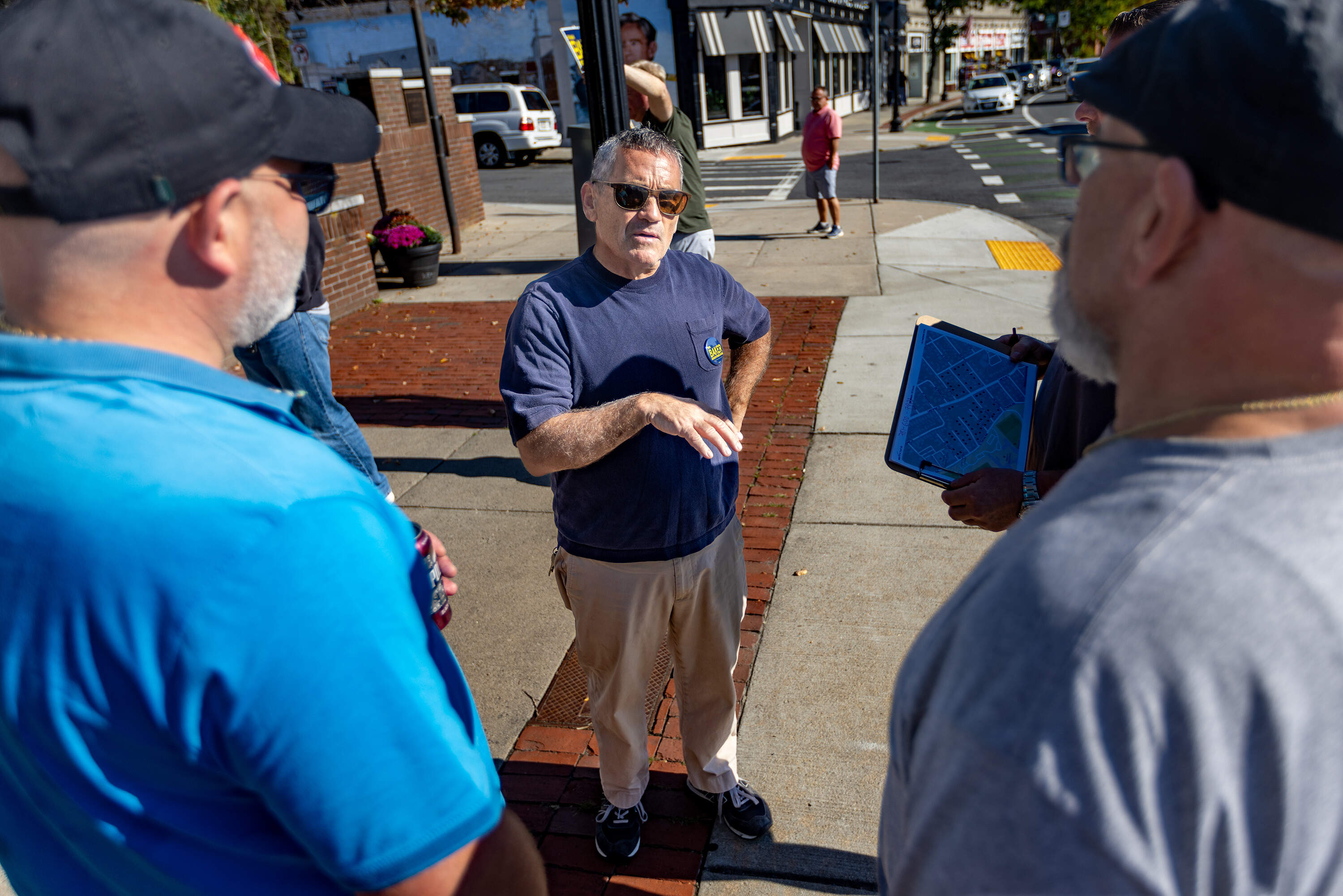 Frank Baker speaks with canvassers on Centre Street before they head out to knock on doors around West Roxbury neighborhoods to tell voters about his candidacy for at-large city councilor. (Jesse Costa/WBUR)
