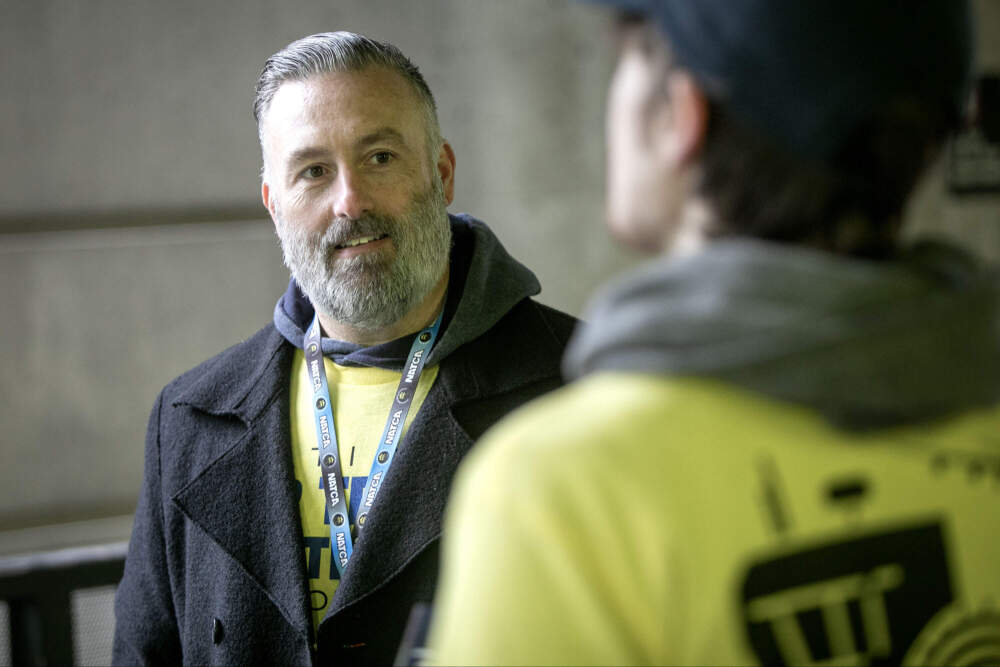 The National Air Traffic Controllers Association New England Regional Vice President Kevin Curtiss talks with NATCA members as they hand out leaflets at Logan airport on Tuesday. (Robin Lubbock/WBUR)