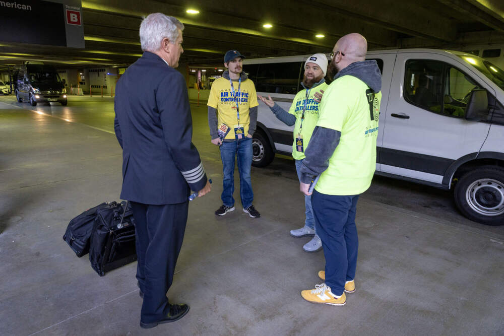 Members of the National Air Traffic Controllers Association (NATCA) talk with a pilot leaving Logan airport's Terminal B. (Robin Lubbock/WBUR)