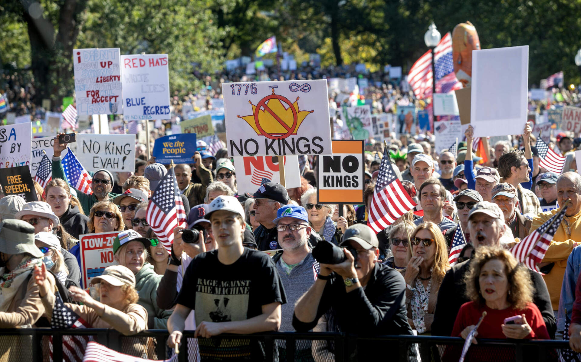 Protesters wave banners at the "No Kings" rally on Boston Common. (Robin Lubbock/WBUR)
