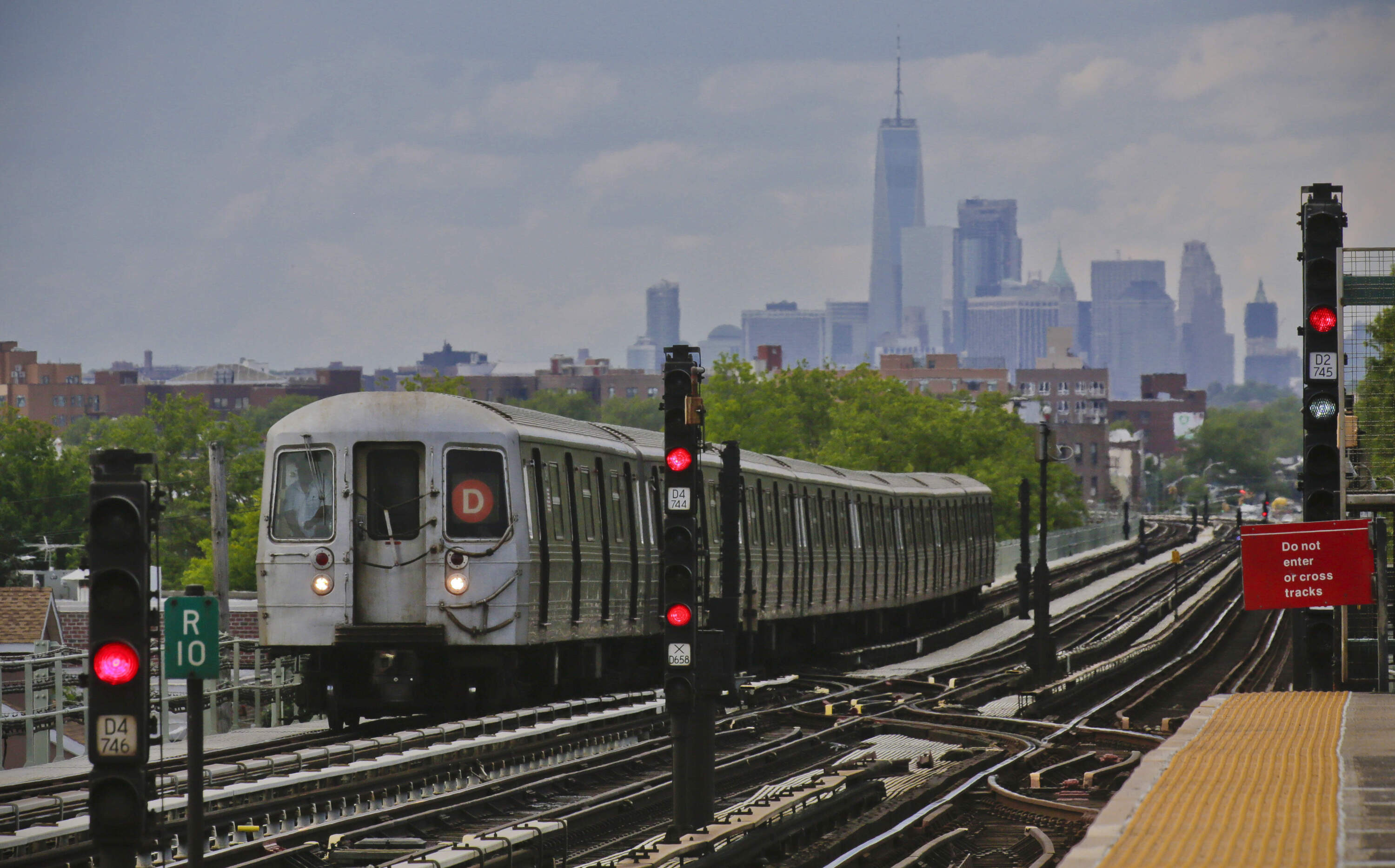 A subway approaches an above ground station in the Brooklyn borough of New York with the New York City skyline in the background. (Bebeto Matthews/AP)