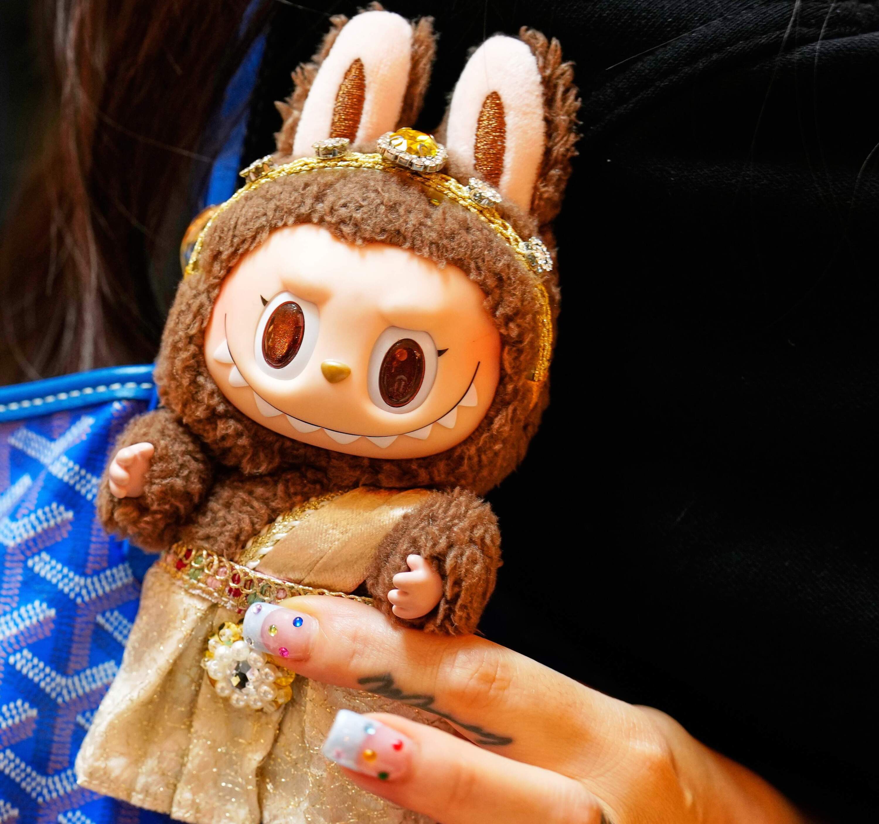 FILE - Diep Nguyen shows a Labubu doll to media during the opening of Germany's first shop for Labubu plush dolls in Berlin, July 25, 2025. (AP Photo/Markus Schreiber, File)