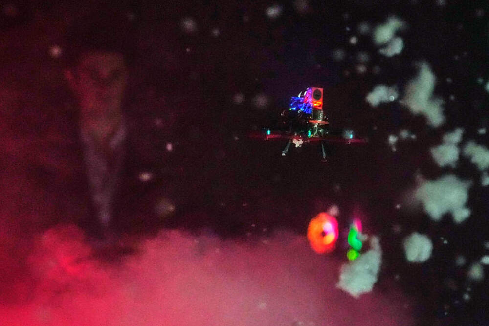 A tiny drone flies through a simulated snowstorm at night at a laboratory at WPI. (Charles Krupa/AP)