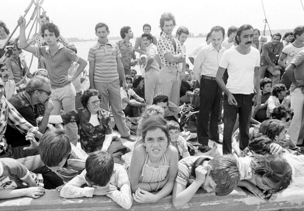 Cuban refugees wait at the port of Mariel, Cuba, aboard a boat bound for Key West, Florida, on Saturday, April 23, 1980. (Jacques Langevin/AP)