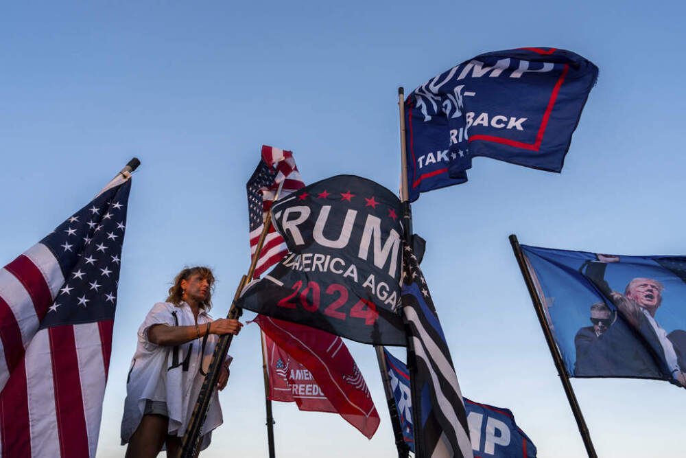 Nikki Fuller, 56, sets up flags on her truck near the Mar-a-Lago estate of President-elect Donald Trump, Monday, Nov. 11, 2024, in Palm Beach, Fla. (AP Photo/Julia Demaree Nikhinson)