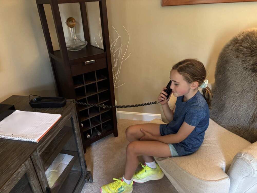 Claire Ladd calls a friend to tell a joke. (Patty Wight/Maine Public)