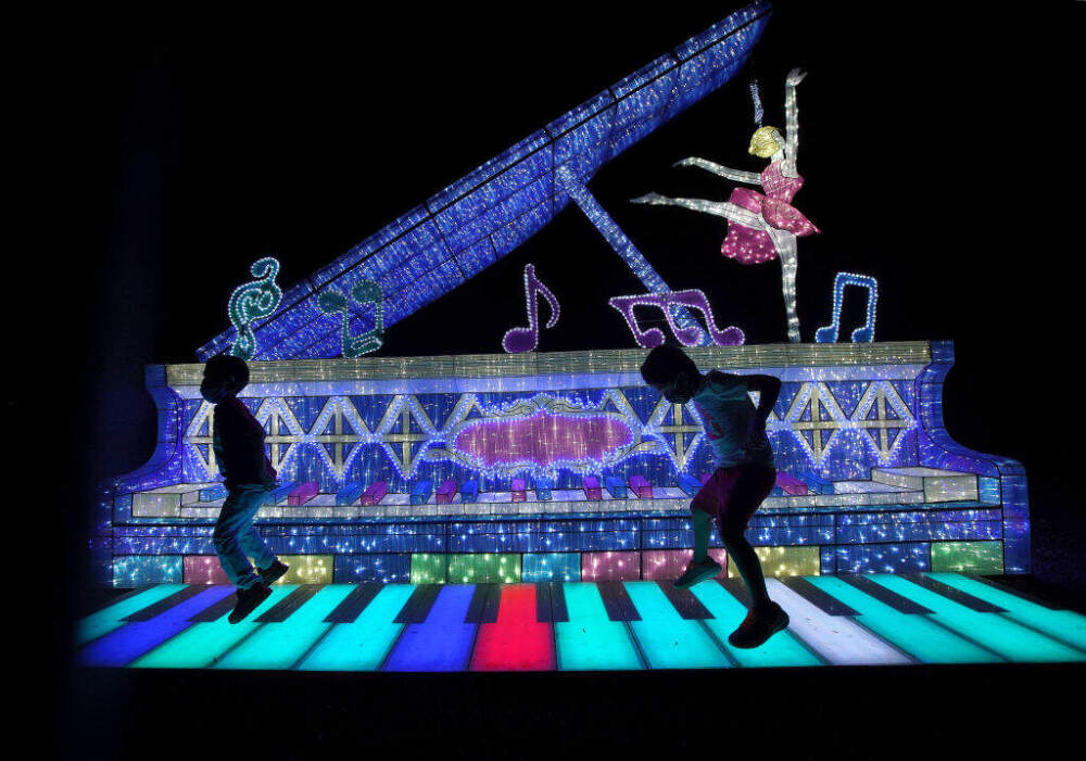 Children play on a touch-sensitive musical keyboard during the Boston Lights display at the Franklin Park Zoo in 2020. (Barry Chin/The Boston Globe via Getty Images)