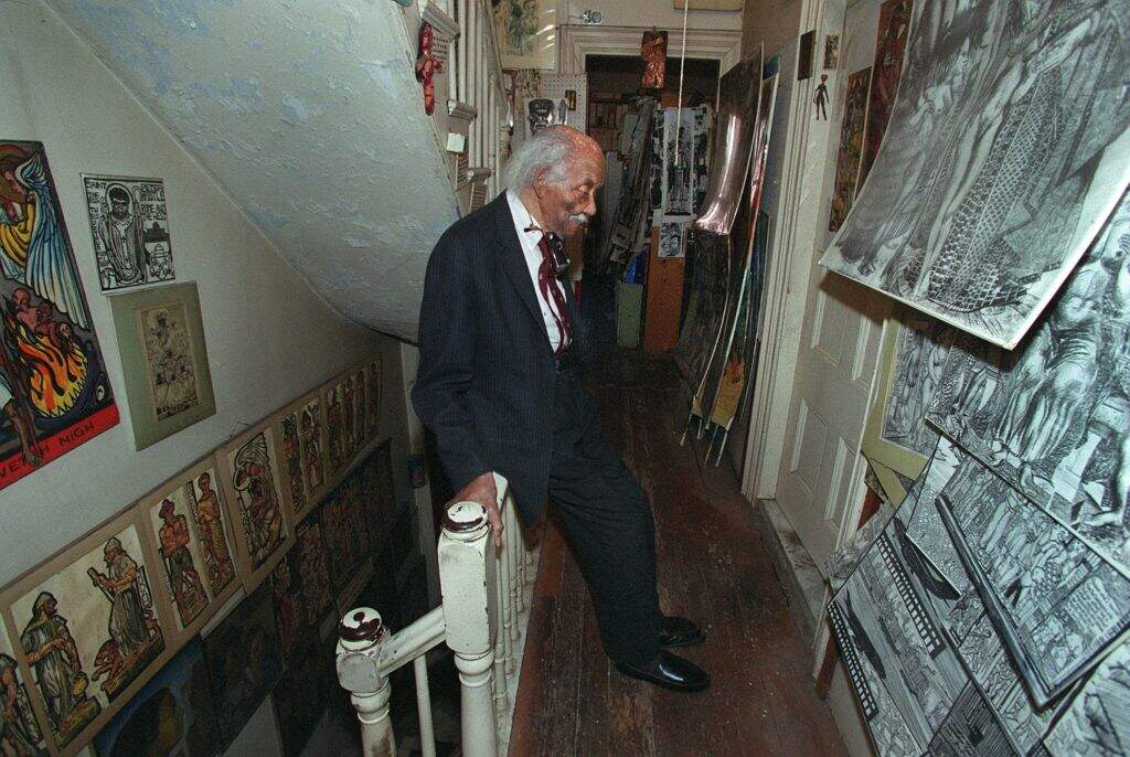 Crite in his home on Feb. 28, 2002. He covered the walls with artwork. (Photo by Pat Greenhouse/The Boston Globe via Getty Images)