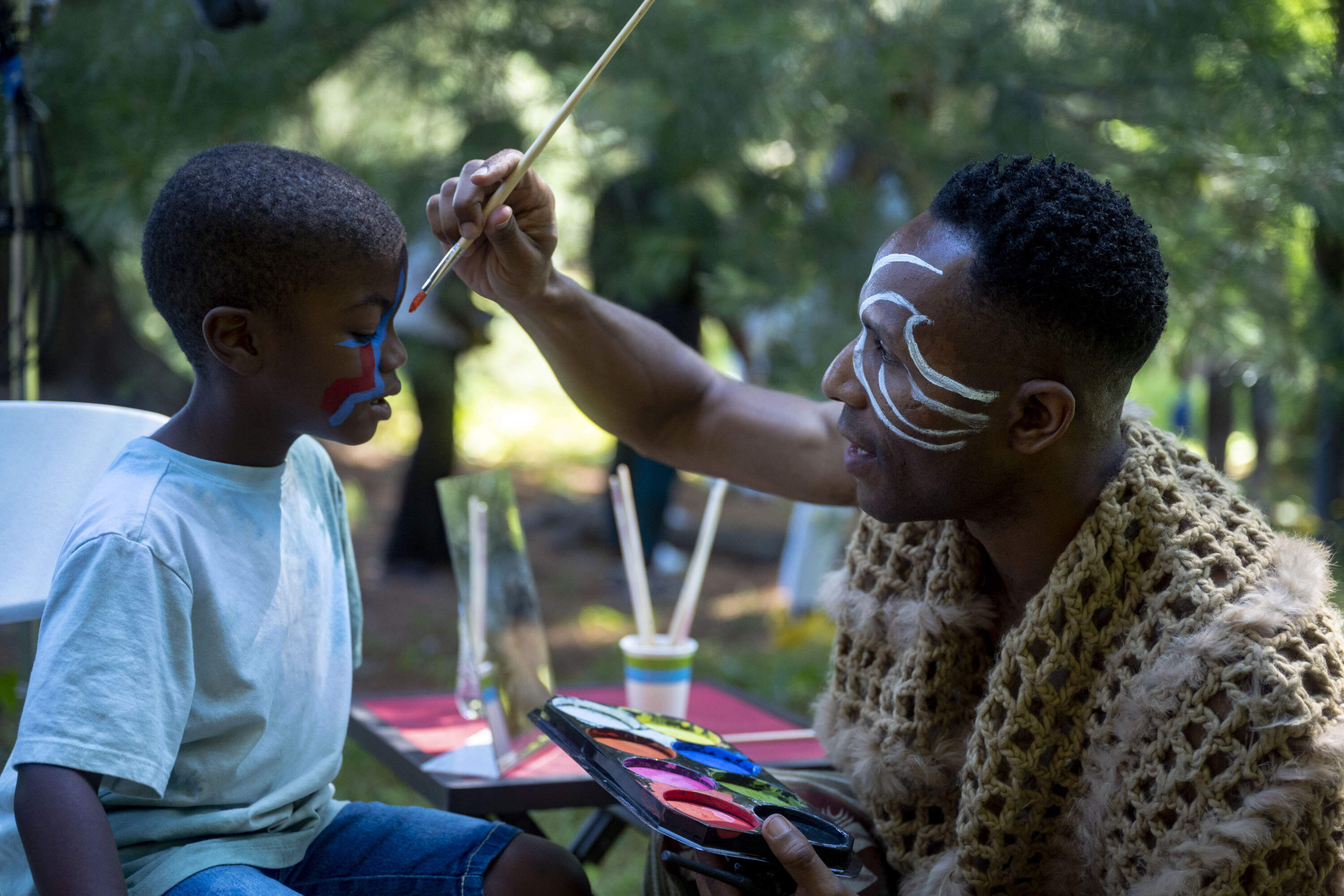 Artist Daniel Callanhan paints a "MassQ" on a young MassQ Ball attendee. (Courtesy Nikolai Alexander)