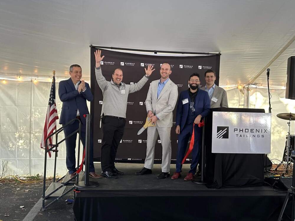 Phoenix Tailings CEO Nick Myers, center, cuts a ceremonial ribbon. (Mara Hoplamazian/New Hampshire Public Radio)