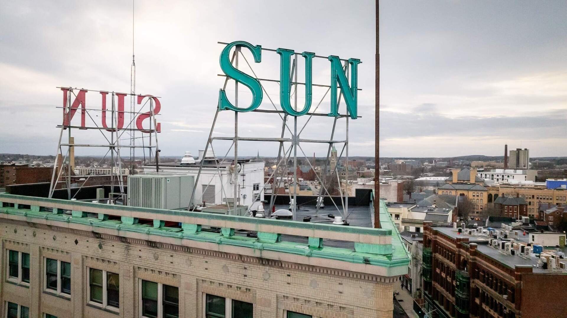 The "Sun" signs atop the 10-story Lowell Sun Building, which will be relit for the first time since 2017 on Monday. (Courtesy of Marte Media)