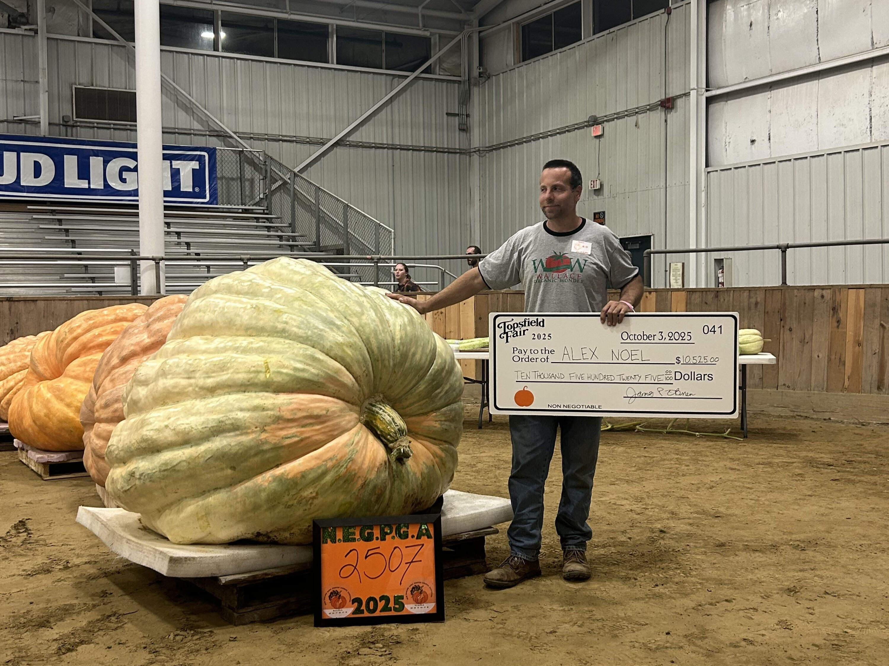 Alex Noel with his first place pumpkin at the Topsfield Fair. (Amanda Beland/WBUR)