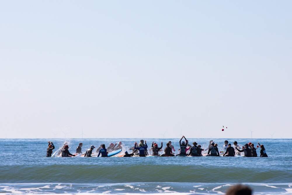 A group of surfers gathered in a circle for Gnome Surf's end of season paddle out for mental health, Westport, Massachusetts, 2025. (Courtesy Gnome Surf)