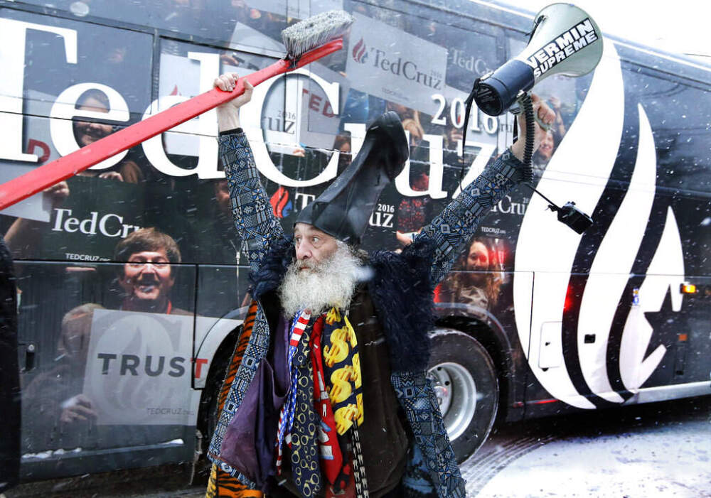 FILE - In this 2016 file photo, Vermin Supreme raises his arms as the bus of Republican Sen. Ted Cruz, R-Texas, rolls away after a presidential campaign event in Manchester, N.H. (Elise Amendola/AP)