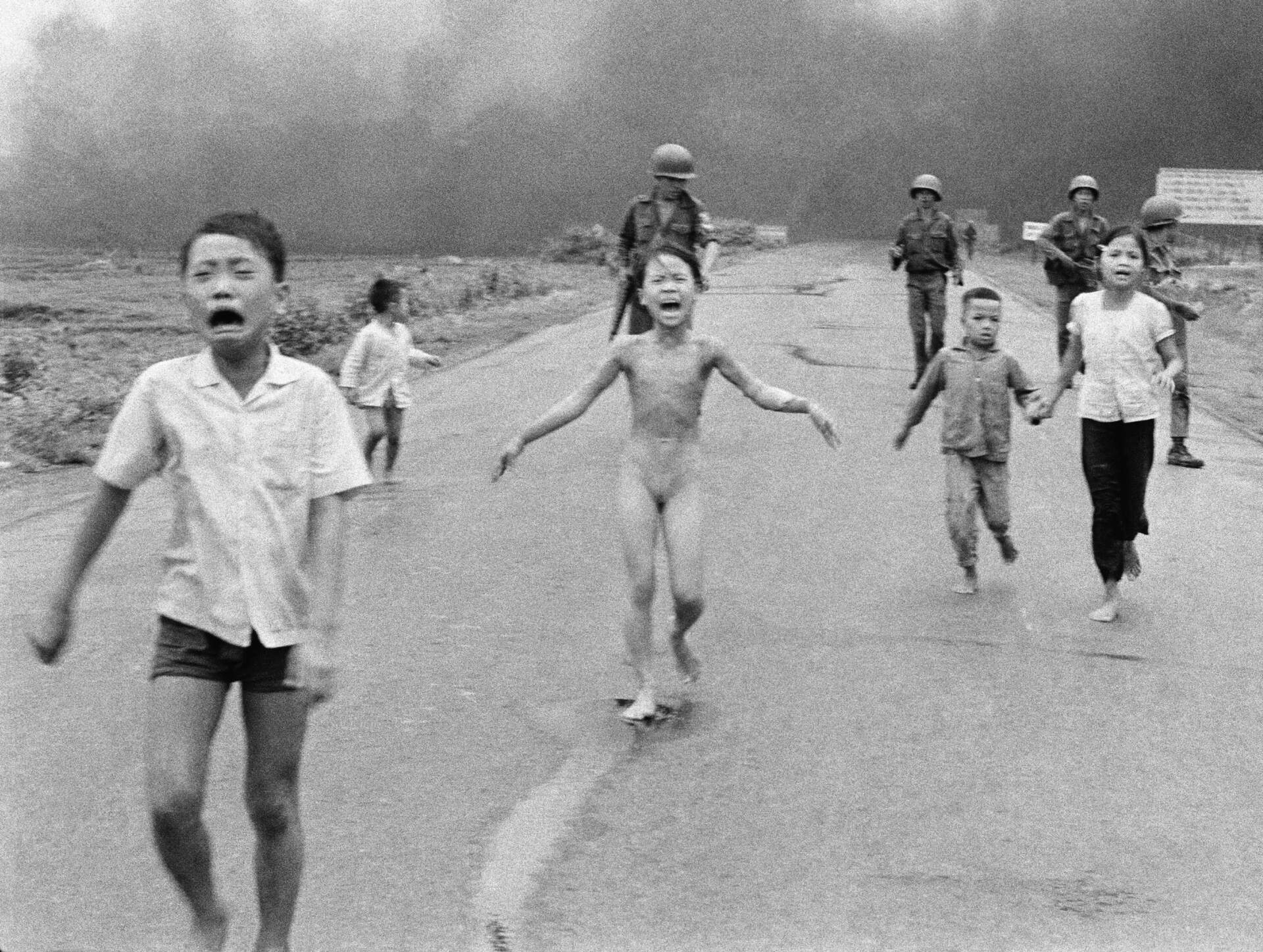 South Vietnamese forces follow after terrified children, including 9-year-old Kim Phuc, center, as they run down Route 1 near Trang Bang after an aerial napalm attack on suspected Viet Cong hiding places on June 8, 1972. A South Vietnamese plane accidentally dropped its flaming napalm on South Vietnamese troops and civilians. (Nick Ut/AP)