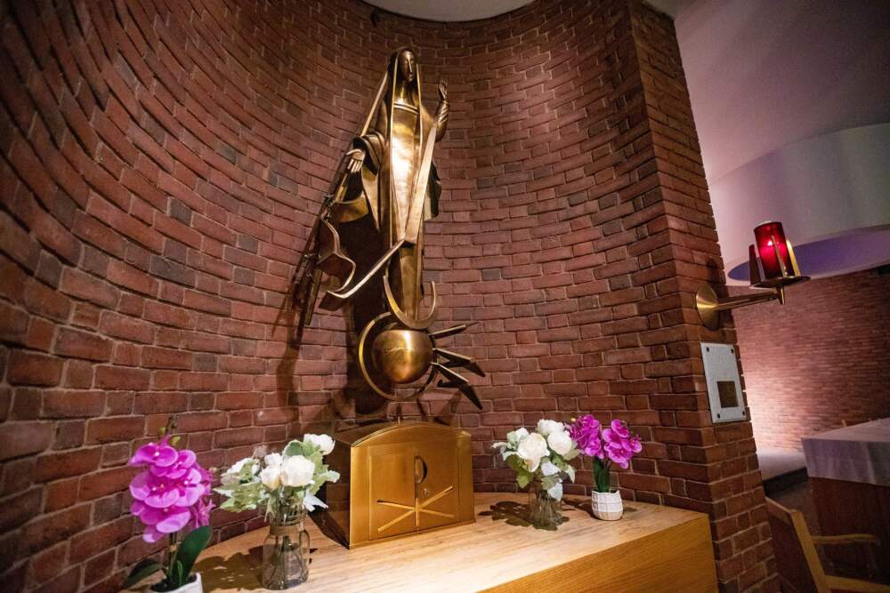 A statue of the Virgin Mary standing atop a globe with planes flying around it at the Logan Airport chapel. (Jesse Costa/WBUR)