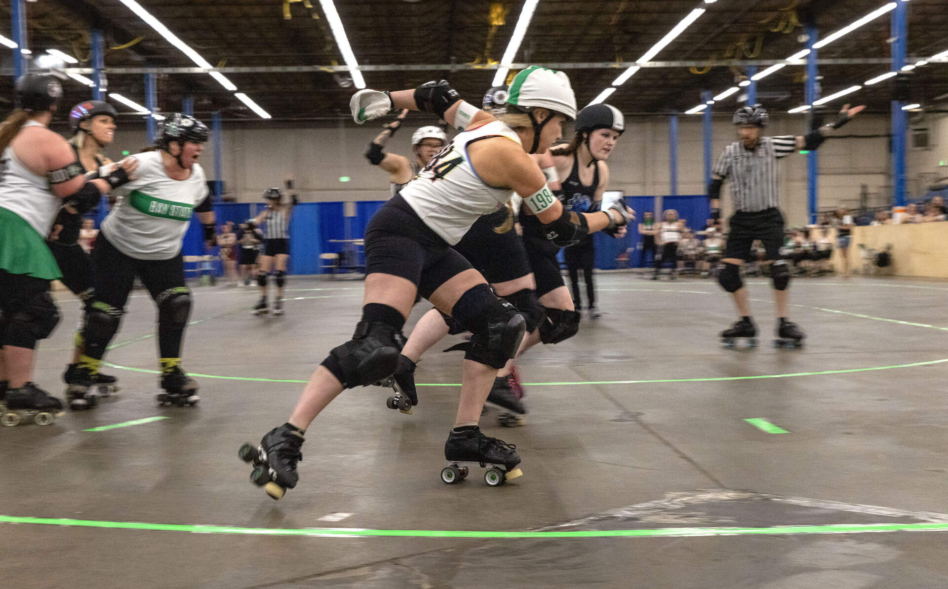 A pivot attempts to race around opposing blockers at a roller derby game in Wilmington, Mass. (Robin Lubbock/WBUR)