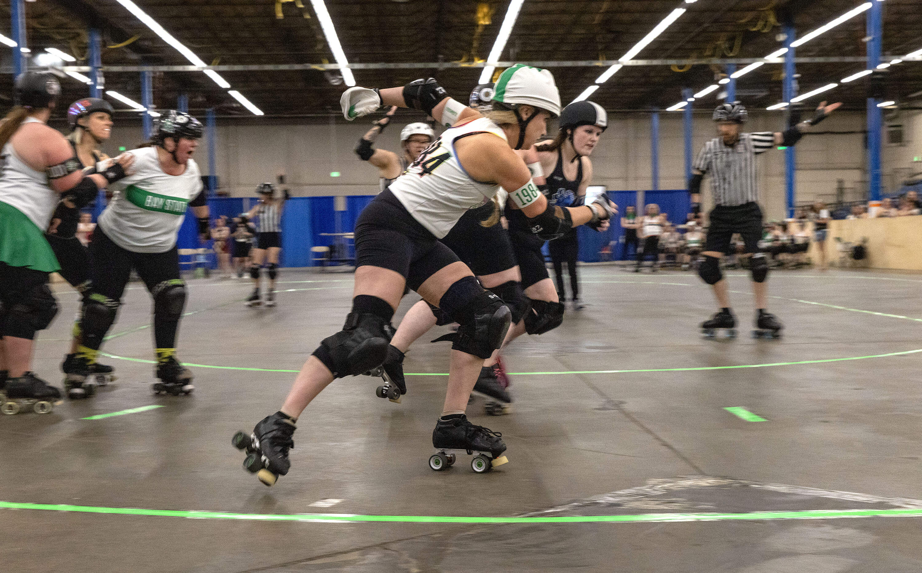 A pivot attempts to race around opposing blockers at a roller derby game in Wilmington, Mass. (Robin Lubbock/WBUR)