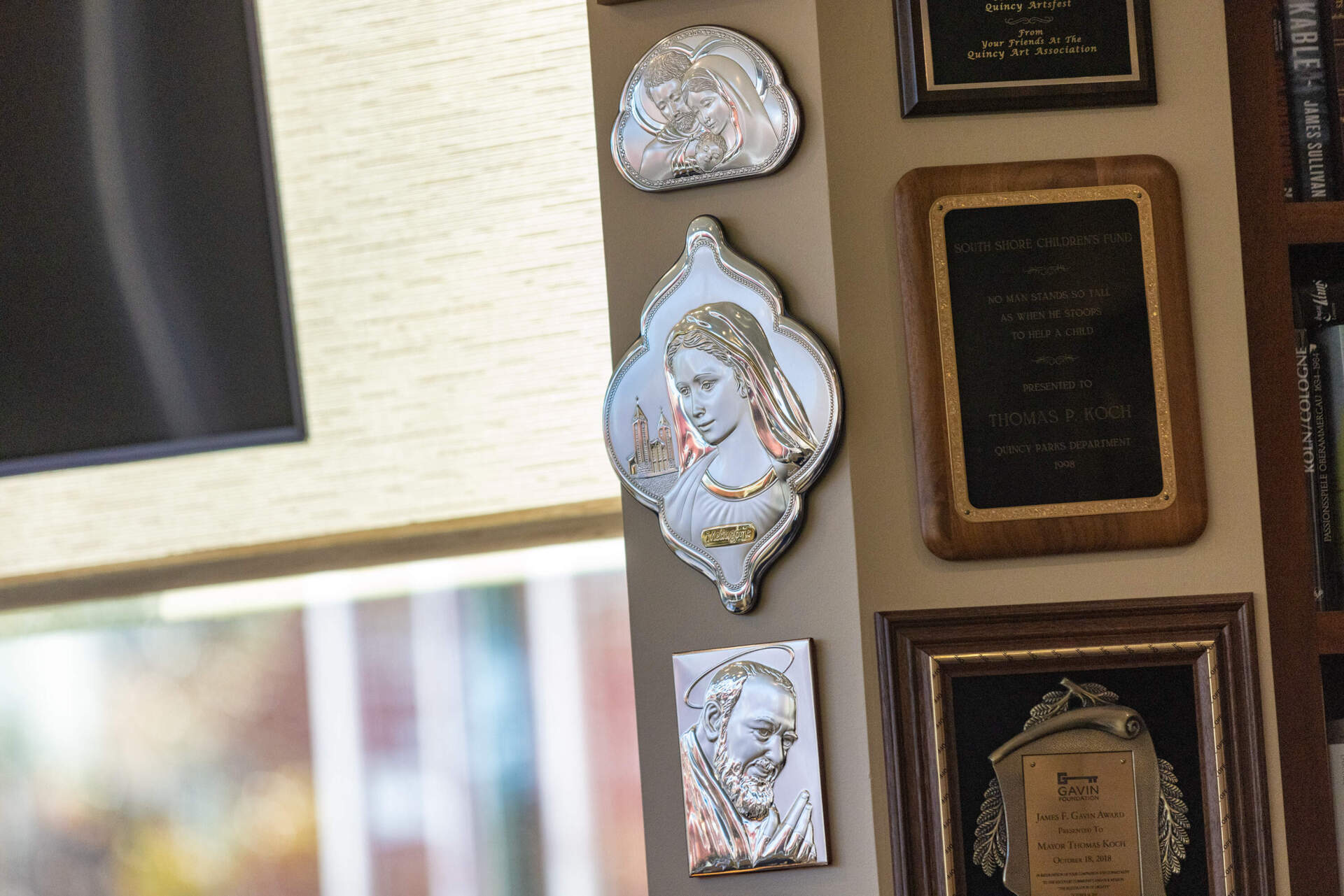 Religious imagery accompanied by achievements and awards adorn the walls of the office of Quincy Mayor Thomas Koch. (Jesse Costa/WBUR)