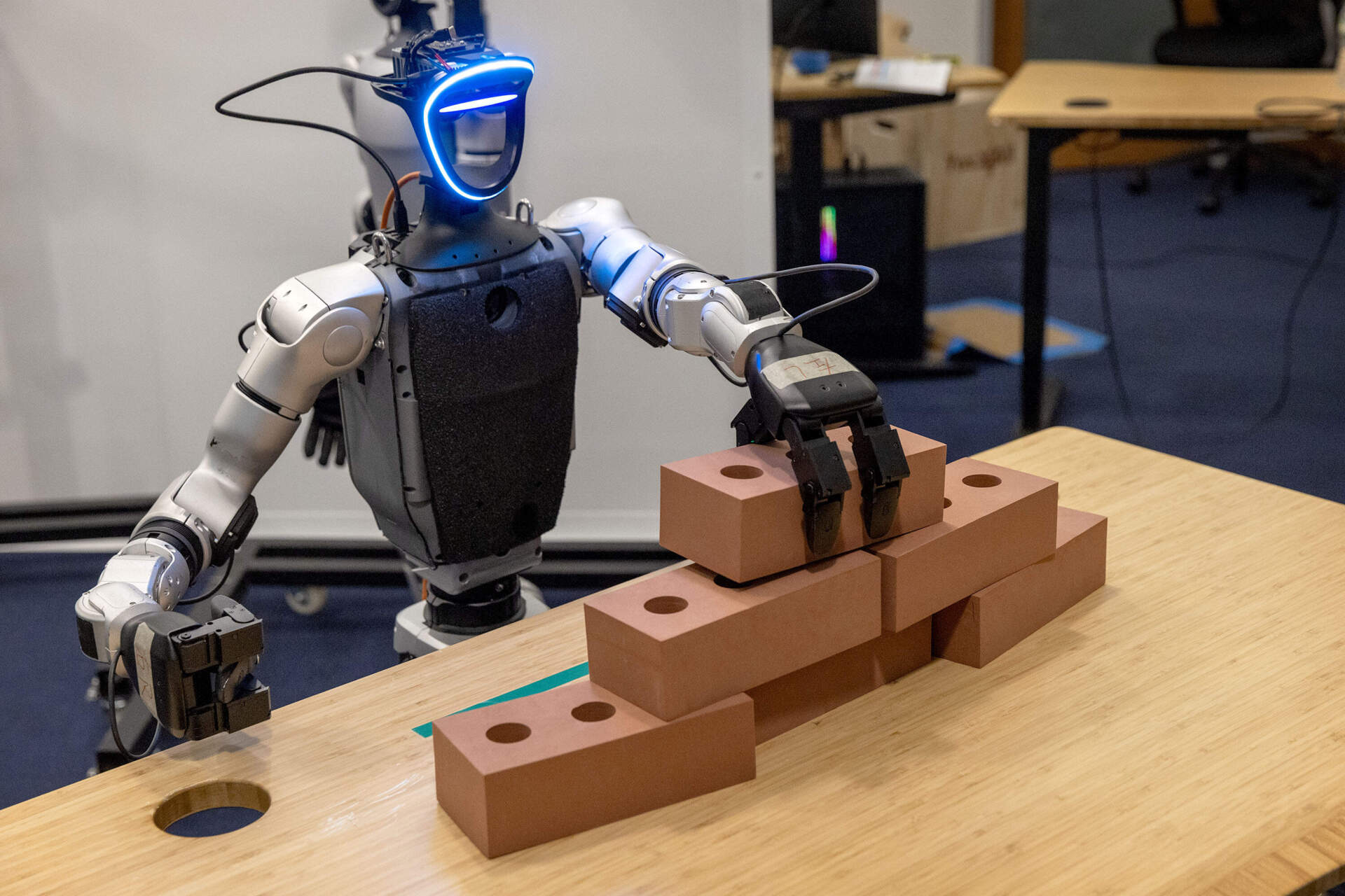 A robot builds a wall of foam bricks. (Robin Lubbock/WBUR)