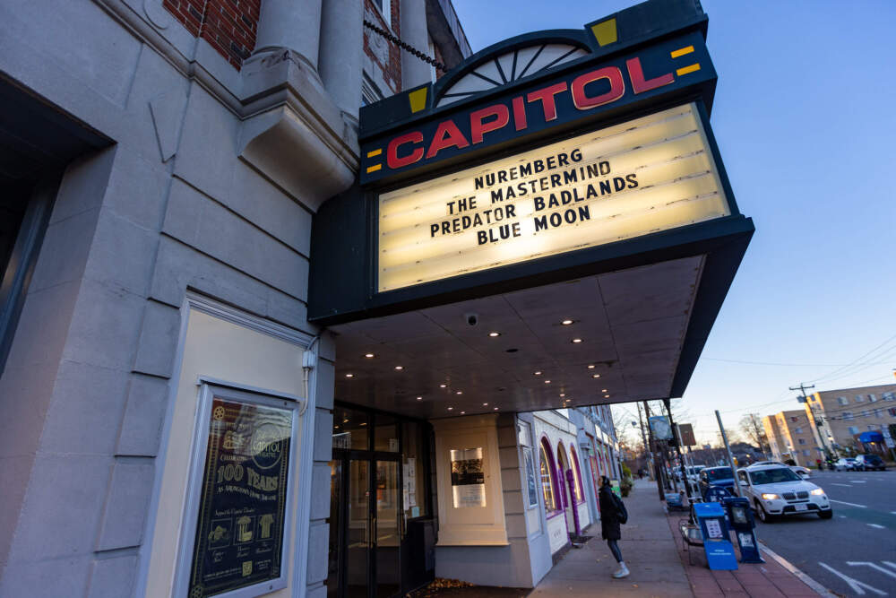 A woman stops to look at movie times in the window of the Capitol Theatre in Arlington. (Jesse Costa/WBUR)