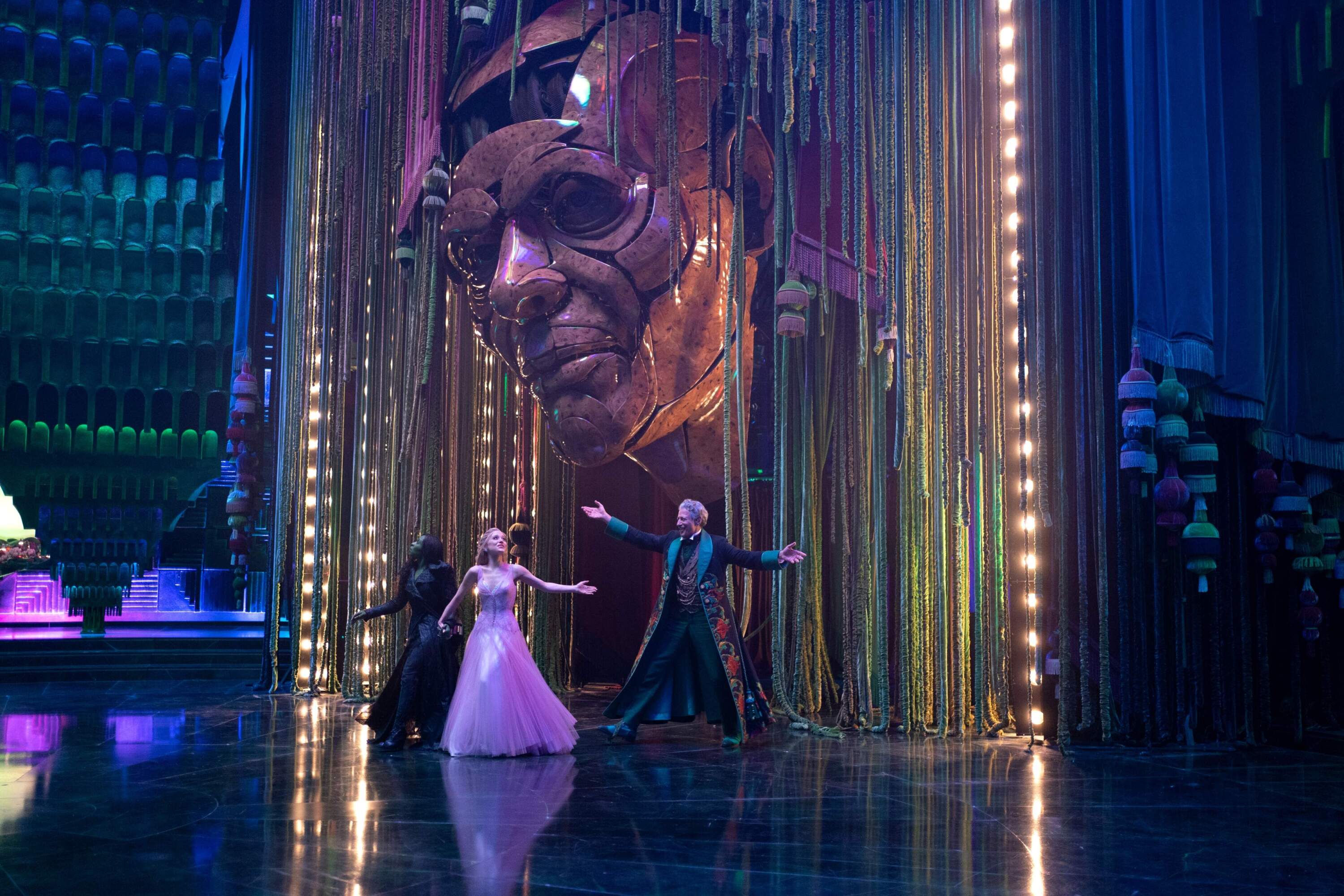 From left: Cynthia Erivo, Ariana Grande and Jeff Goldblum in "Wicked: For Good." (Courtesy Giles Keyte/Universal Pictures)