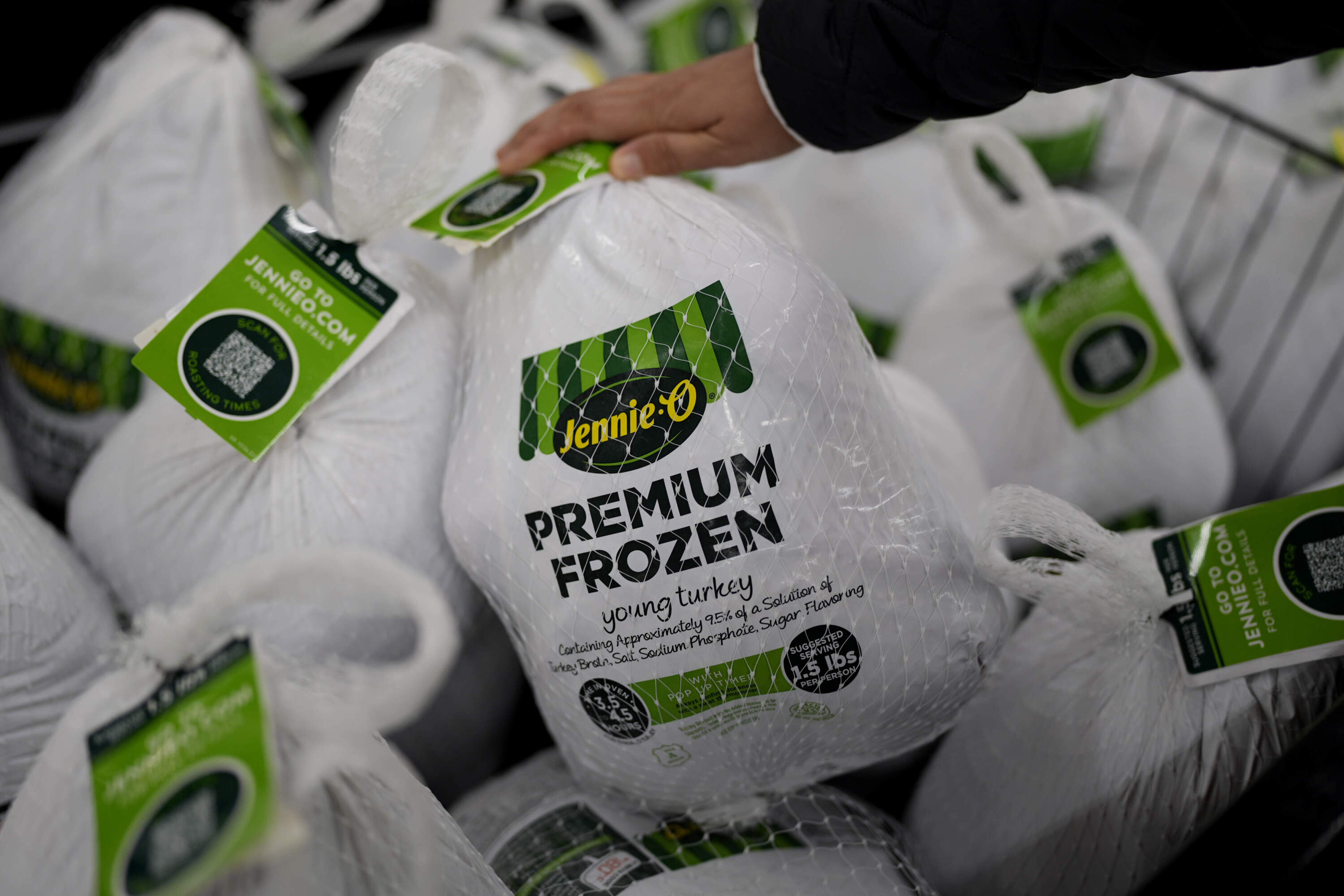 A shopper checks premium frozen young turkey at a grocery store in Glenview, Ill., Monday, Nov. 25, 2024. (Nam Y. Huh/AP)