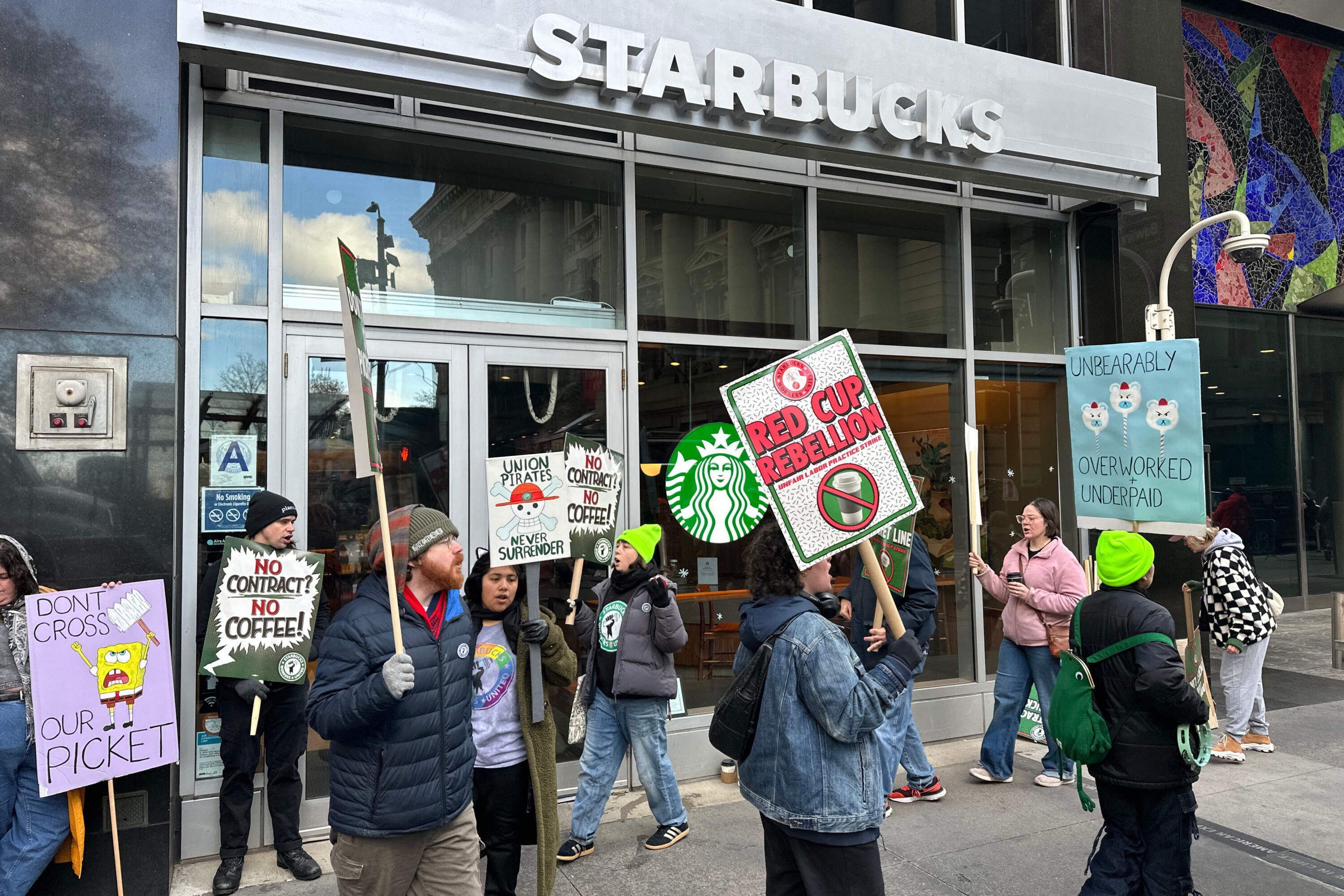 People picket at a Starbucks in New York on Friday, Nov. 14, 2025, as striking workers call for a union contract. (Ted Shaffrey/AP)