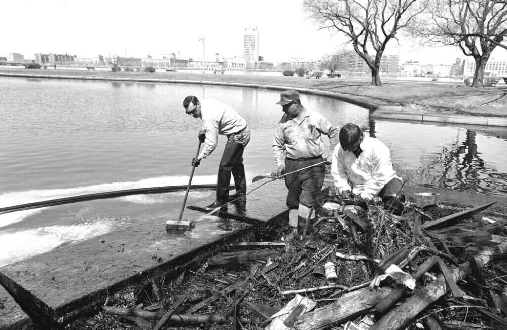 Workmen experiment with a method of removing thick oil spilled on shore line of a lagoon in the Charles River in Boston on April 6, 1965. (Walter Green/AP)