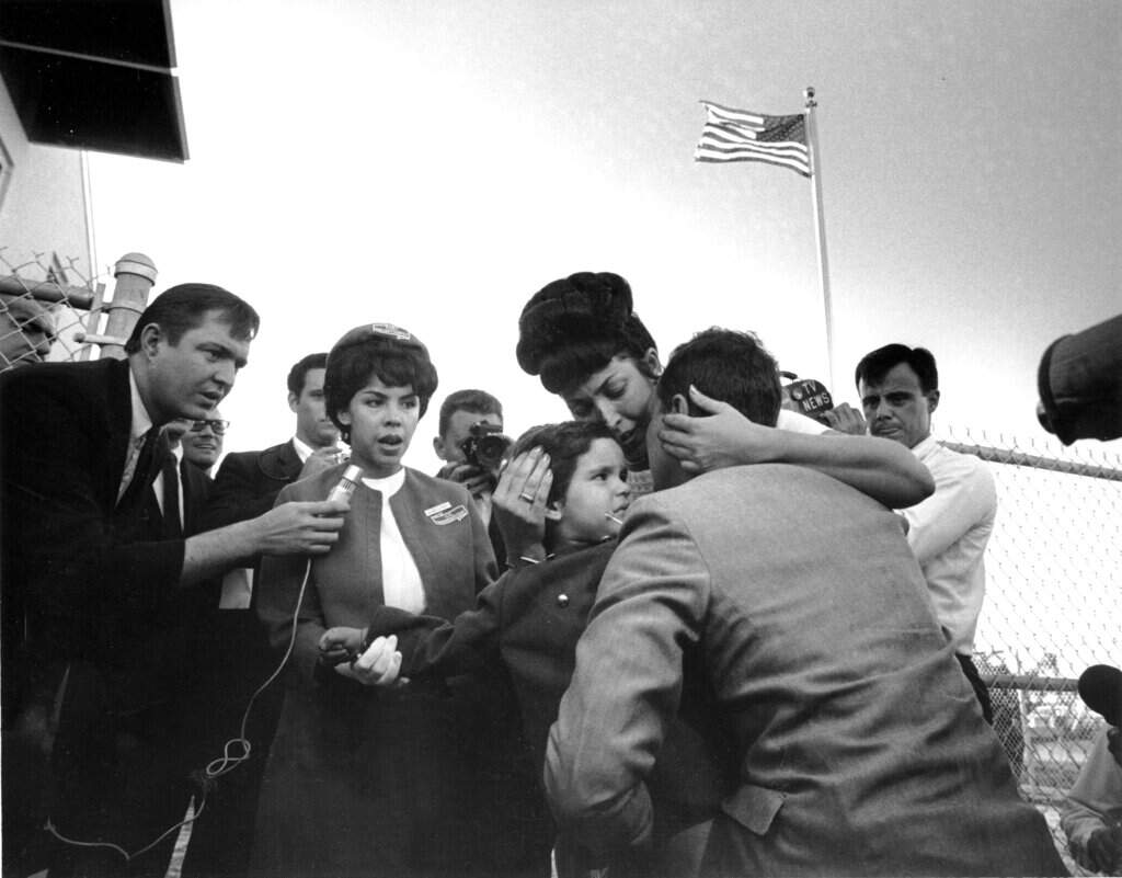 Enrique Carneado, of Passaic, New Jersey, enjoys a tearful reunion with his wife Dulce and daughter Margarita after they arrived in Miami from Cuba on December 1, 1965. (AP)