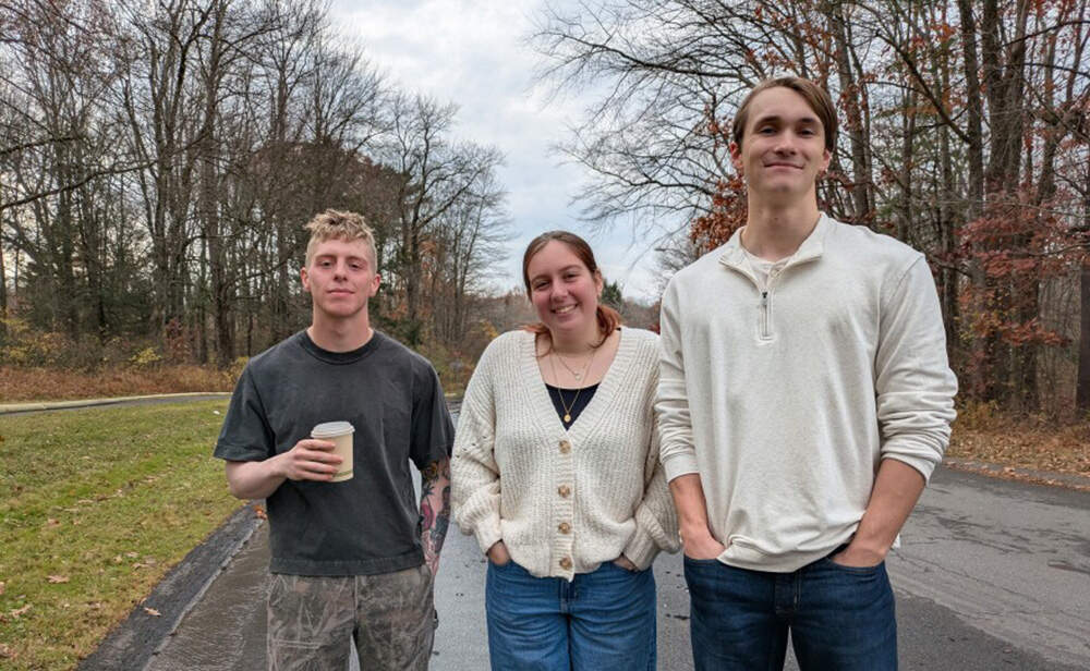 At right, Owen Ball, a UMass Amherst student whose apartment and belongings were destroyed, returns to the site of the fire with two friends on Sunday. (Jill Kaufman/NEPM)