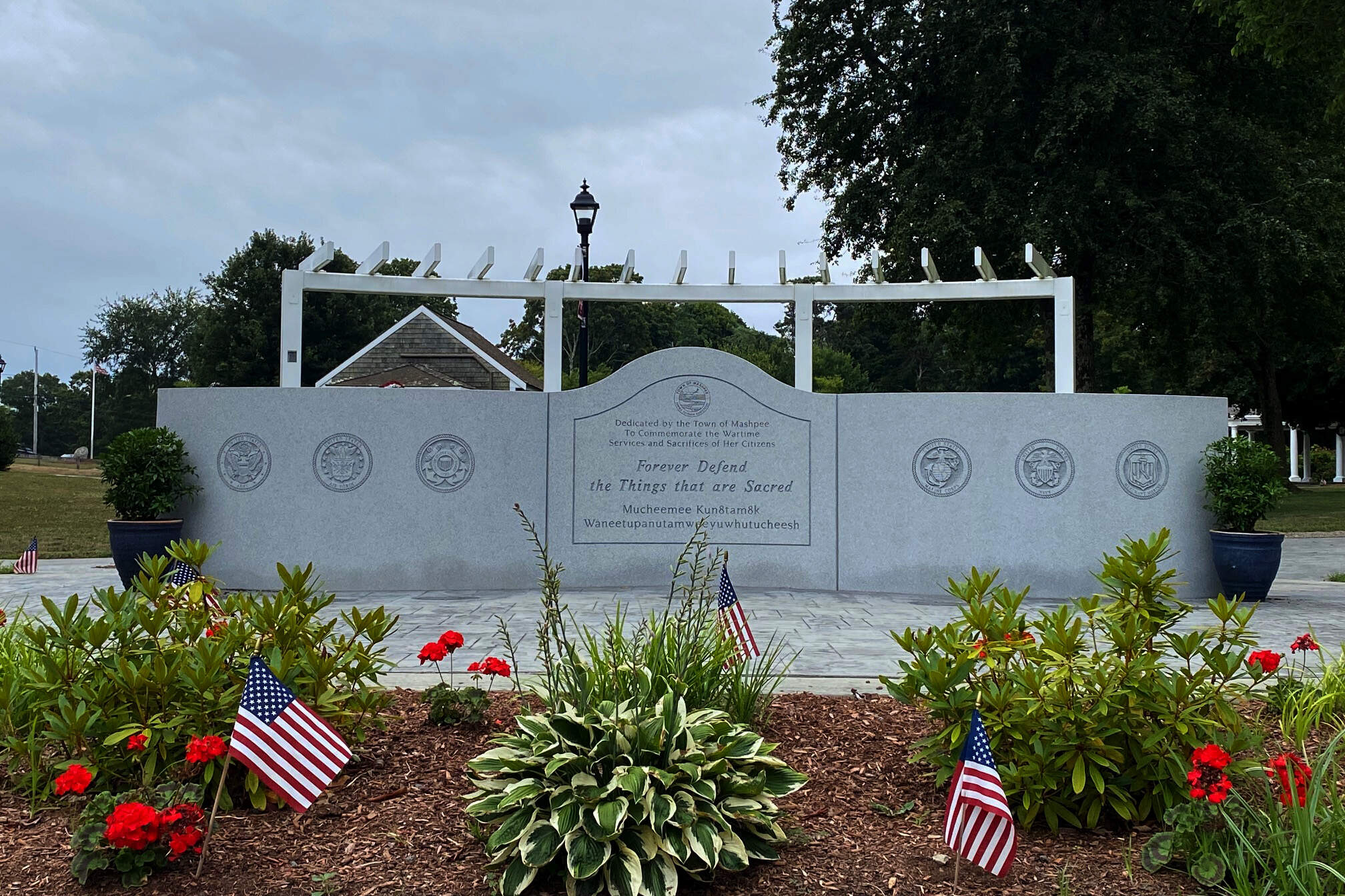 The front of the Mashpee Veterans Monument, depicting the seals of each branch of the military and the phrase "Forever Defend the Things that are Sacred" in English and Wôpanâak. (Courtesy of Richard DeSorgher)