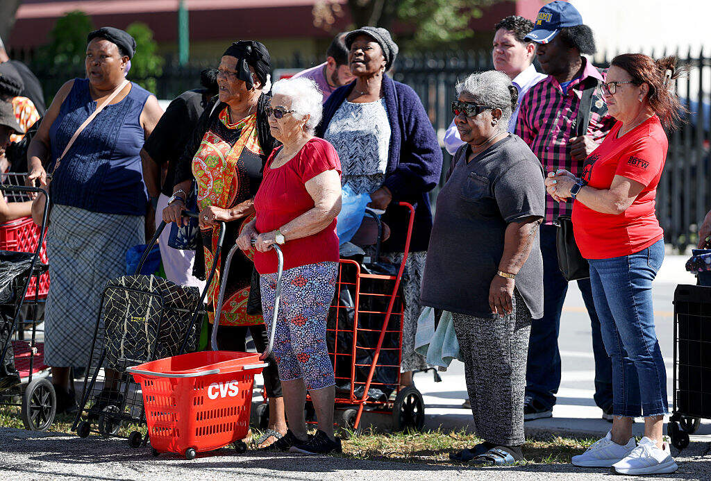 People in need wait in line to receive groceries from Curley's House Food Bank in Miami, Florida on October 30, 2025. (Joe Raedle/Getty Images)