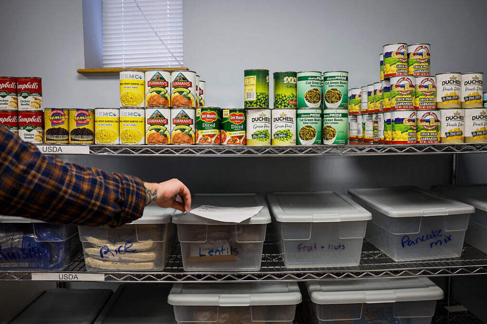 Kevan Mullen, a client advocate at Action for Boston Community Development, selects canned goods and pantry staples for a client's order on October 30. (Erin Clark/The Boston Globe via Getty Images)