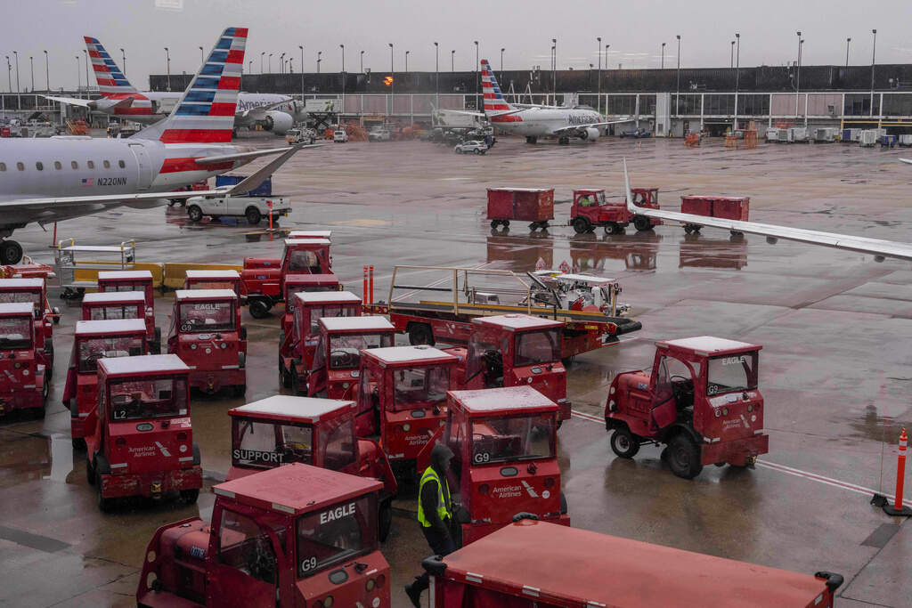 A worker stands on the tarmac amid American Airlines planes at Chicago O'Hare International Airport in Chicago, Ill., Sunday, Nov. 9, 2025. (AP Photo/Adam Gray)