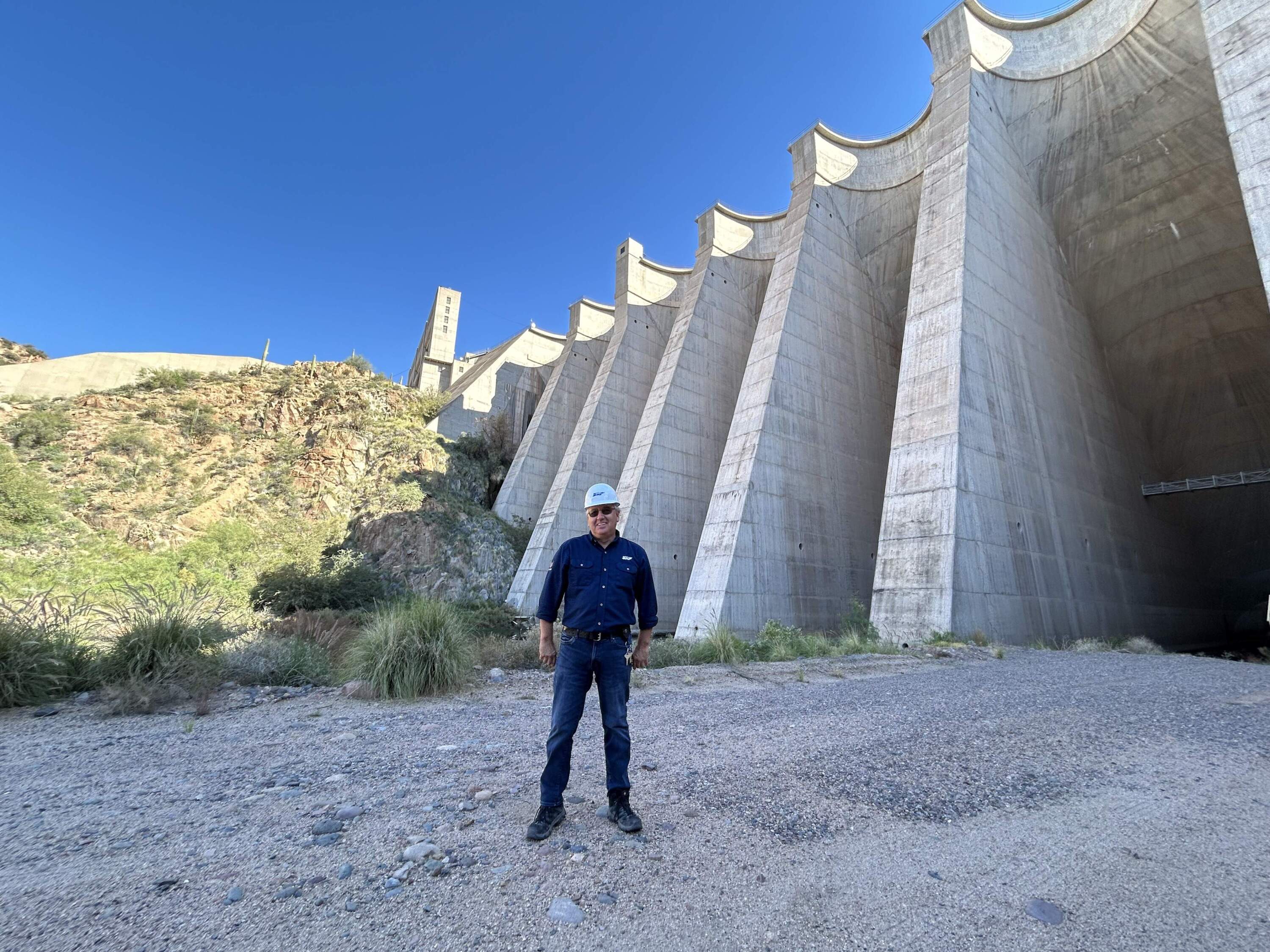 Don McMillan stands next to the concrete structure of the dam. (Peter O'Dowd/Here &amp; Now)
