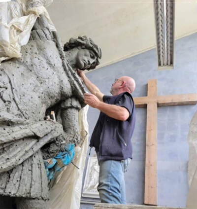 Italy-based sculptor Sergey Eylanbekov working on a statue of St. Michael, commissioned by the city of Quincy. WBUR obtained the photo in response to a public records request — the photo was shared with the mayor's office in a text exchange in May 2024.