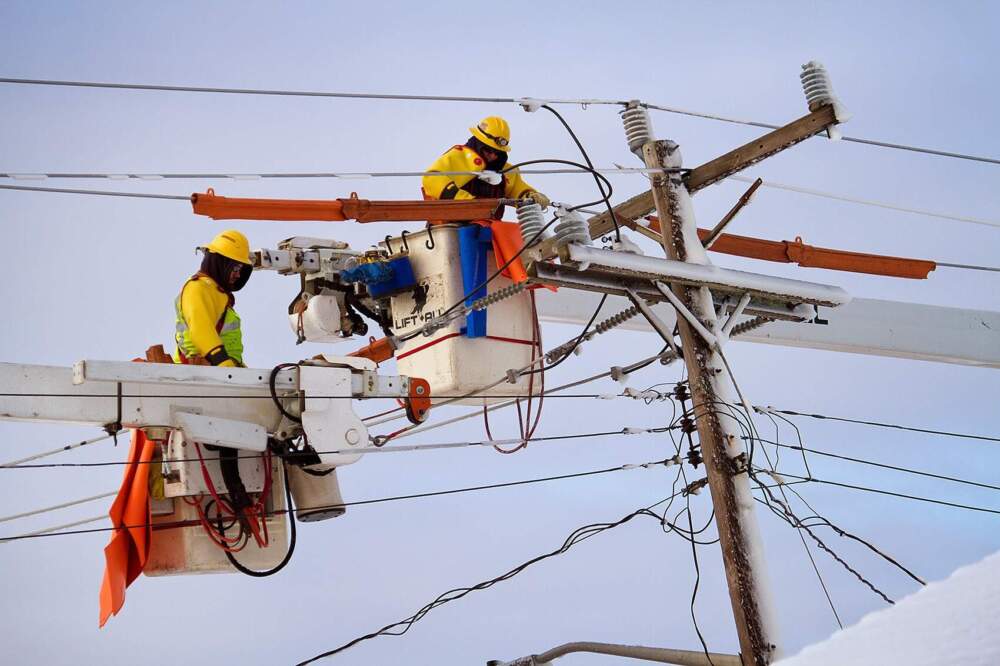 Workers repair downed power lines on Ocean Street in Marshfield. (Jesse Costa/WBUR)
