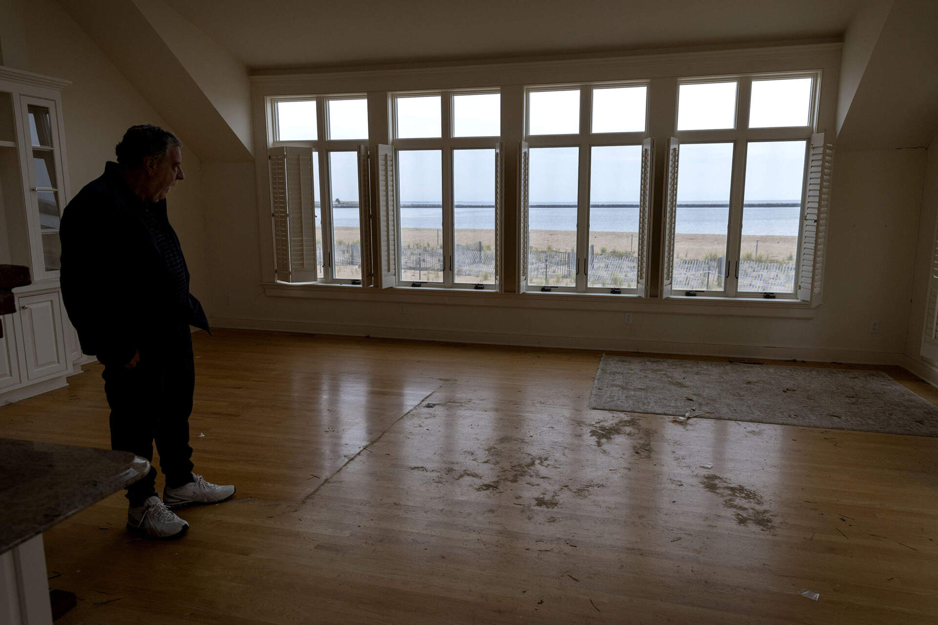 Stanton Sacks looks out across the Merrimack River to the ocean from his flood damaged beachfront property on 73rd Street on Plum Island. (Robin Lubbock/WBUR)