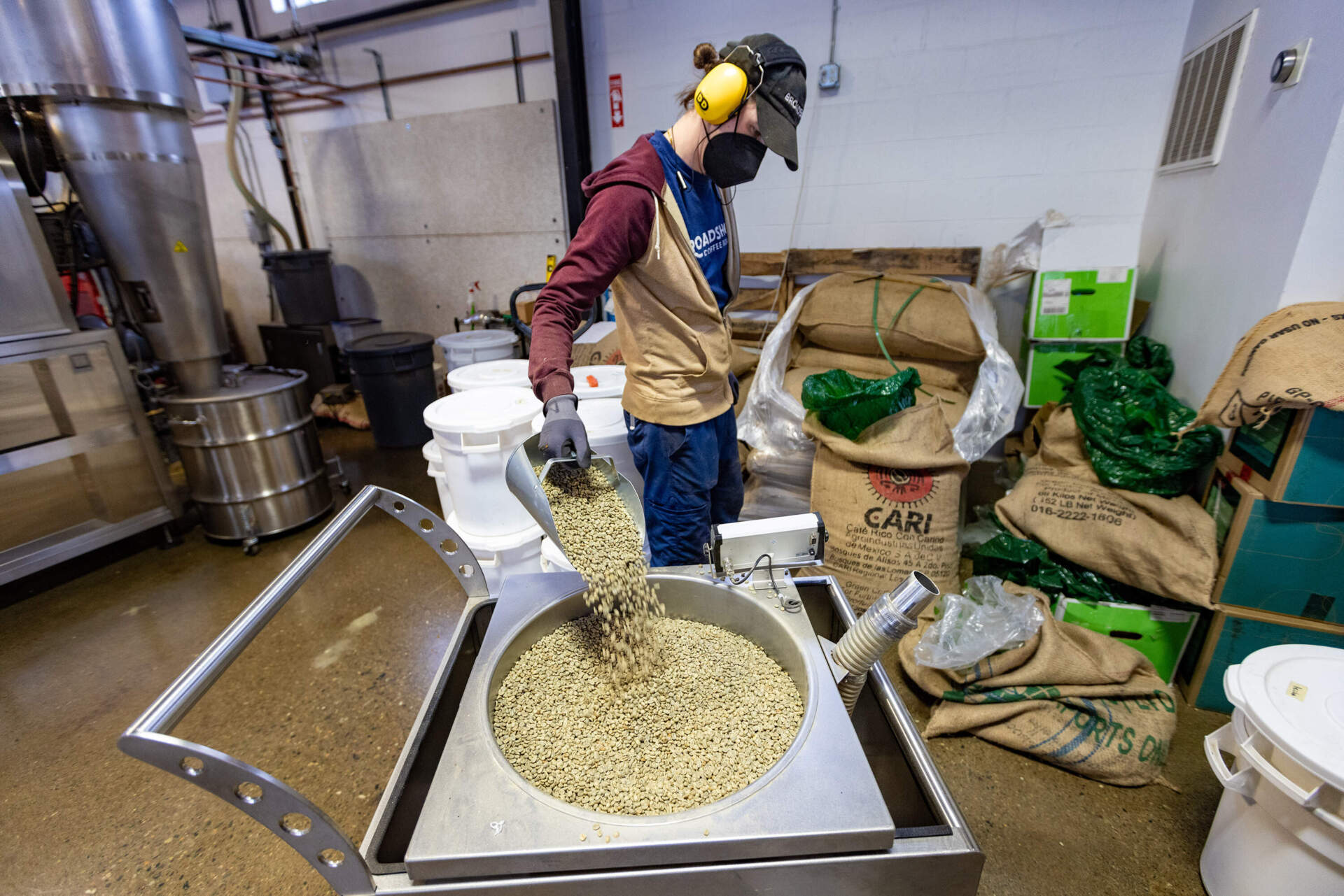 Coffee roaster Michael Nunziato measures green coffee beans preparing for the next batch to be roasted at Broadsheet Coffee Roaster in Somerville. (Jesse Costa/WBUR)