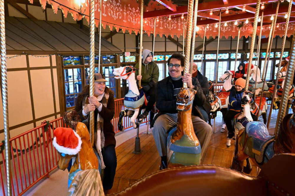 Christina and Raul Nieves of Windsor Locks ride the Bushnell Park Carousel in Hartford, Conn., Friday, Dec. 5, 2025. Scenes from the Hallmark movie "Ghost of Christmas Always" were filmed at the carousel. (Jessica Hill/AP)