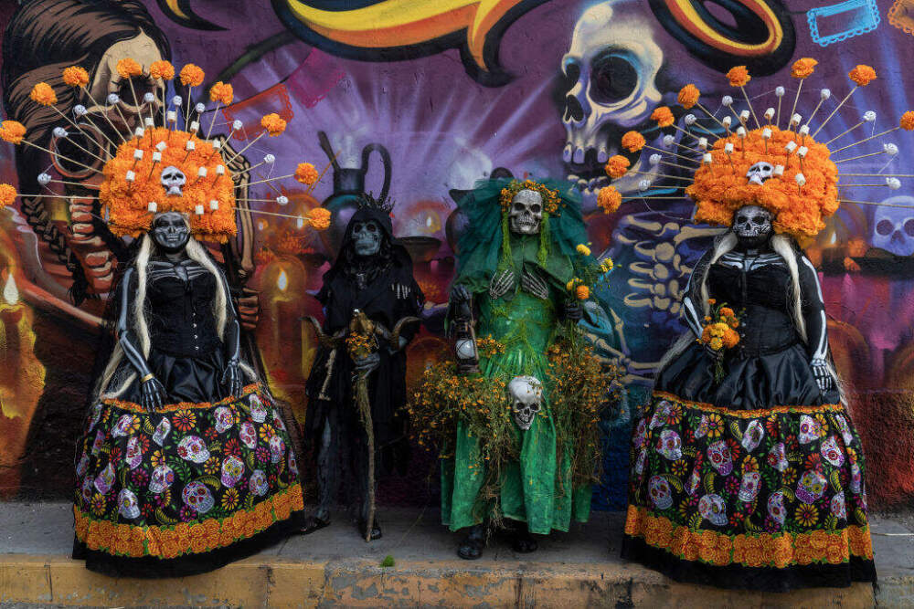 People dressed in Day of the Dead costume pose for a photo during 'Day of the Dead' celebrations on November 2, 2024 in Oaxaca, Mexico. (Photo by Cristopher Rogel Blanquet/Getty Images)