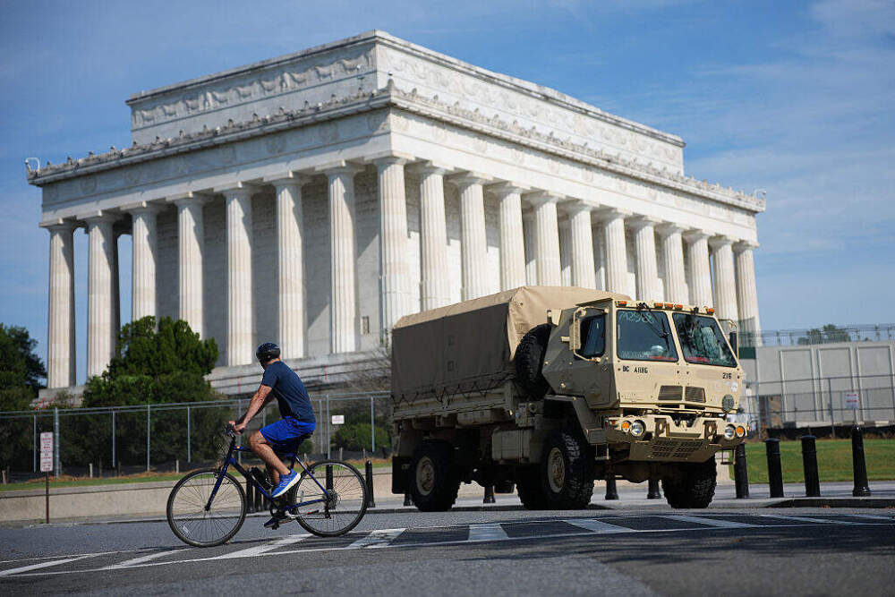 A cyclist passes a National Guard vehicle near the Lincoln Memorial on August 14 in Washington. (Kevin Dietsch/Getty Images). (Kevin Dietsch/Getty Images)